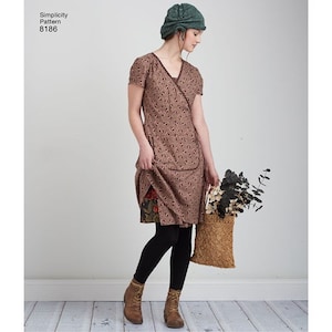 May include: A brown and white floral print wrap dress with short sleeves and a V-neckline. The dress is paired with black tights and brown ankle boots. The model is wearing a green knitted hat.