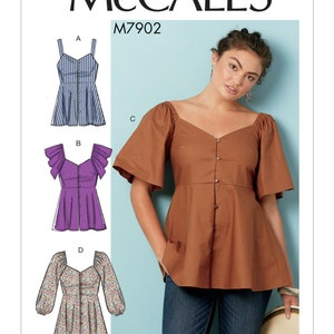 May include: McCall's sewing pattern M7902 for a women's blouse with four different styles. The first style is a sleeveless blouse with a striped pattern. The second style has short sleeves with ruffles. The third style has short, puffed sleeves. The fourth style has long, puffed sleeves with a floral print.