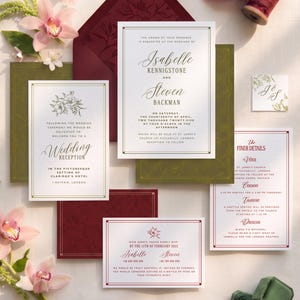May include: A wedding stationery set featuring white cards with gold and burgundy text, including an invitation for Isabelle Kennigstone and Steven Backman, a reception card, an RSVP card, and a details card, all accented by burgundy envelopes and ribbon.