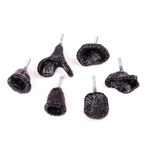 May include: Six black metal cabinet knobs with different designs. The knobs have a rustic, vintage look and are perfect for adding a touch of character to any home.