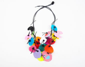 PUZZLE necklace No. 7, three-row, with colorful synthetic resin elements on black rubber cord, with button closure