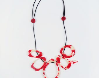 Anillo/collar ornamental, blanco marfil y rojo, longitud ajustable.