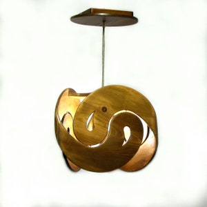 Op de afbeelding: Een houten hanglamp met een uniek, wervelend ontwerp. De lamp is gemaakt van natuurlijk hout en heeft een warme, uitnodigende gloed.