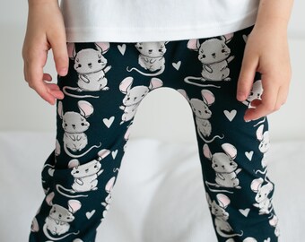 May include: Dark green leggings with a white and pink mouse print. The leggings have a heart pattern.