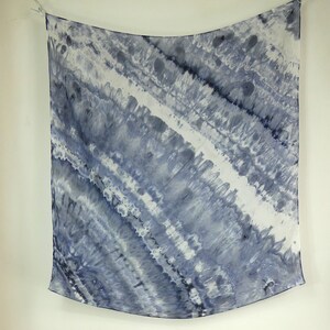 May include: A square, blue and white tie-dye silk scarf with a wavy pattern.