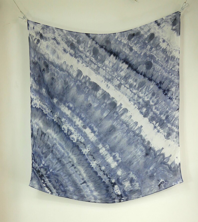May include: A square, blue and white tie-dye silk scarf with a wavy pattern.