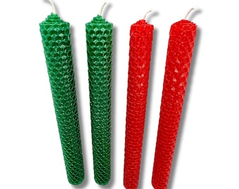Op de afbeelding: Drie bijenwaskaarsen, twee rood en één groen, met een honingraatpatroon.