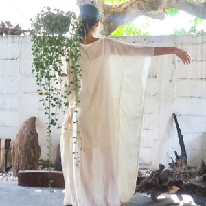 Puede incluir: Un vestido blanco de kaft&aacute;n fluido con un corte holgado y relajado. El vestido est&aacute; hecho de una tela ligera y tiene un dise&ntilde;o simple y elegante.