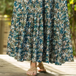 May include: A long, flowing skirt with a blue and brown floral print. The skirt has multiple tiers and is made of a lightweight fabric.
