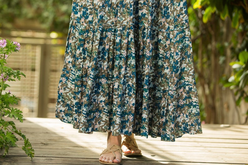 May include: A long, flowing skirt with a blue and brown floral print. The skirt has multiple tiers and is made of a lightweight fabric.