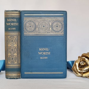 May include: Two antique books titled "Kenilworth" by Scott. The books are bound in teal and gold, with ornate gold detailing on the spines and covers. The book on the right has a decorative gold pattern across the top.