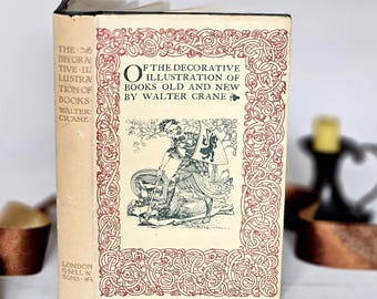 May include: A vintage book titled "The Decorative Illustration of Books Old and New by Walter Crane." The cover features an illustration of a knight in green and black, framed by a red and cream border. The spine is cream-colored with black text.