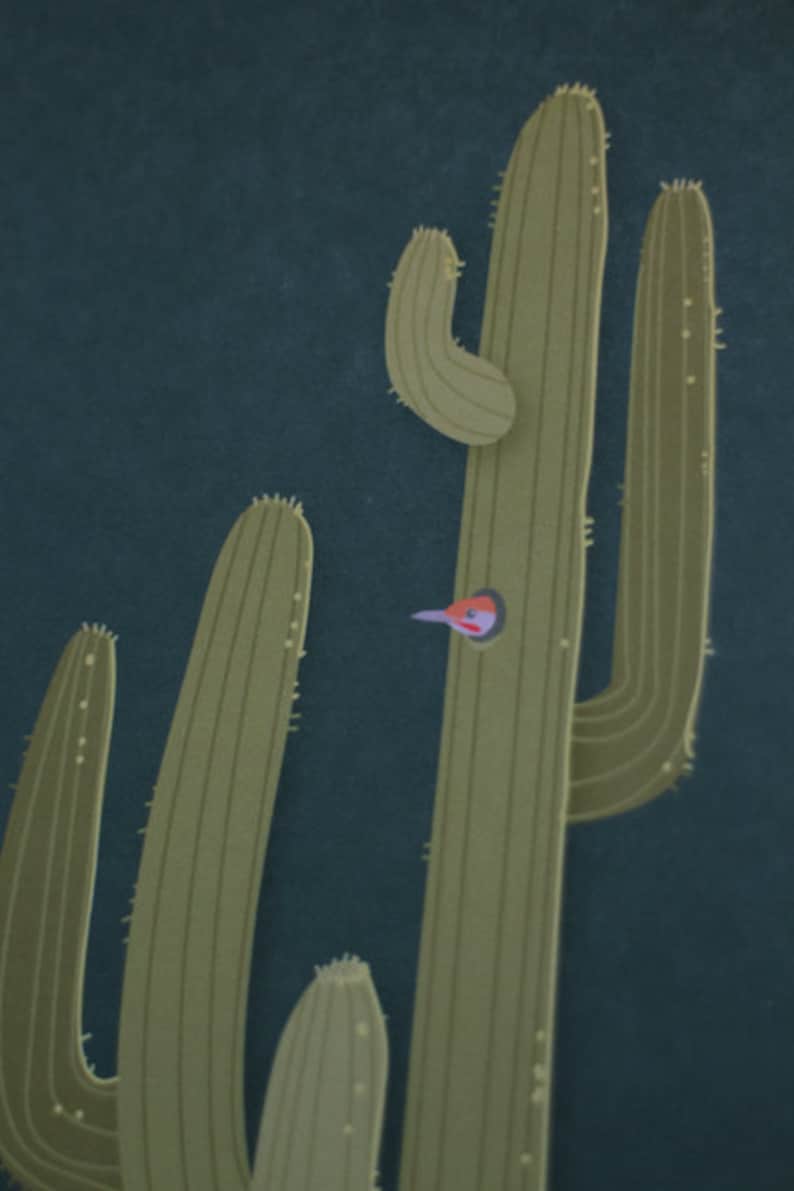 May include: A close-up of a green cactus with a small bird peeking out of a hole in the cactus.