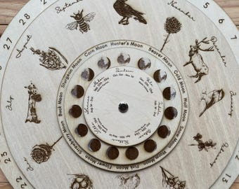 May include: A wooden moon phase calendar with a rotating dial. The calendar features the names of the months, the names of the full moons, and illustrations of animals and plants associated with each month. The calendar is a great way to track the phases of the moon and learn about the folklore associated with each month.