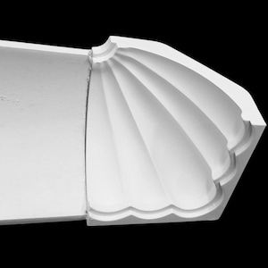 May include: A section of white architectural moulding with a fan-shaped design. The moulding has a smooth, matte finish and is set against a black background. The design features curved, fluted details.