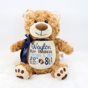 Peut inclure: Un ours en peluche brun avec un ruban bleu et des détails brodés. La broderie comprend le nom Waylon Roy Vienneau, la date du 3 février 2021, l'heure 23h37, le poids 8 lb 1 oz et la longueur 20 pouces.