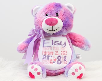 May include: A pink and purple tie-dye teddy bear with a white embroidered patch that says "Eisy Margaret Marie Albert February 25, 2022 21" 8 lb 8 oz".