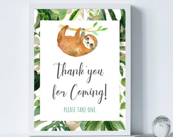May include: A white framed sign with a green and gold tropical leaf border. A watercolor illustration of a sloth hanging from a branch. The text on the sign reads "Thank you for coming! Please take one."