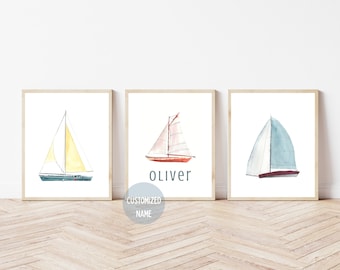 May include: Three framed watercolour paintings of sailboats. The middle frame has the name Oliver written below the sailboat.