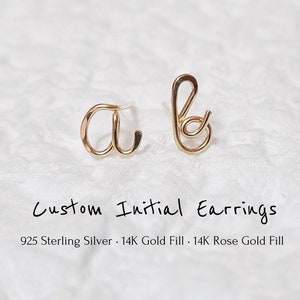 Peut inclure: Une paire de boucles d'oreilles initiales en or, l'une avec la lettre 'a' et l'autre avec la lettre 'b'. Les boucles d'oreilles sont en argent sterling 925 avec un placage or 14K ou un placage or rose 14K.