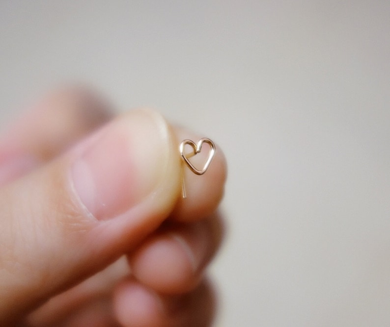 May include: A gold heart-shaped earring with a delicate wire design.
