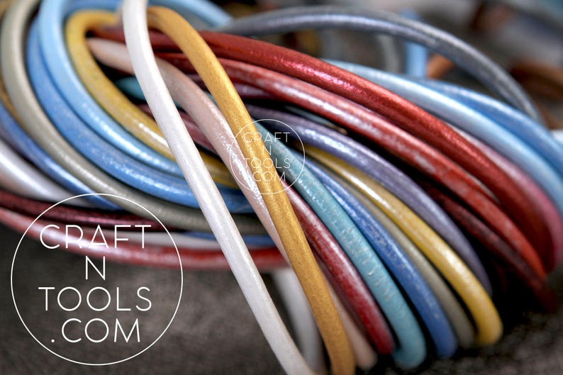 May include: A close-up of a variety of leather cords in different colors, including gold, red, blue, and white. The cords are arranged in a circular pattern, creating a colorful and textured design. The text "CRAFT N TOOLS .COM" is visible in the center of the image.