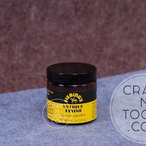 May include: A small jar of Fiebing's Antique Finish in Light Brown. The jar is labeled with the Fiebing's logo, which features a horse. The jar is 4 fluid ounces (118 ml).