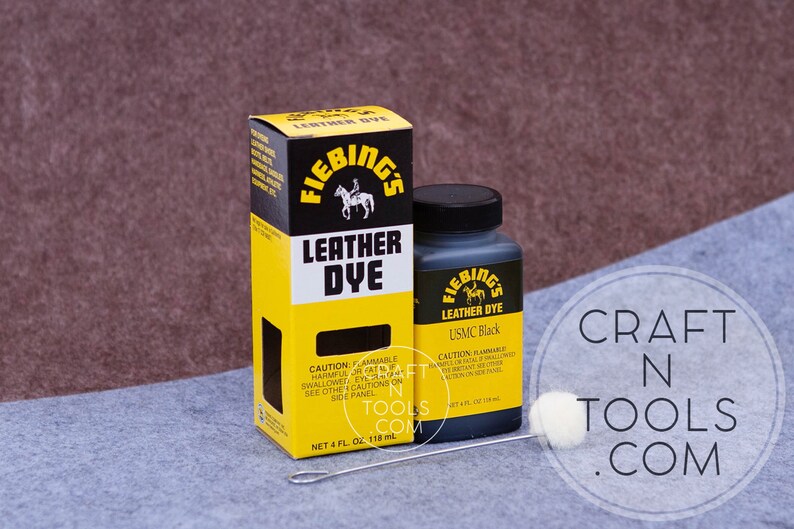 May include: A bottle of Fiebing's Leather Dye in USMC Black, a 4 fl oz (118 ml) bottle with a yellow and black label. The bottle is next to a box of Fiebing's Leather Dye, also in USMC Black, with a yellow and black label. The box is 4 fl oz (118 ml).