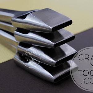 May include: A stack of four metal leather working tools with rectangular cutting heads. The tools are silver and reflect light, with a dark background. The tools are arranged in a diagonal stack. The logo "CRAFT N TOOLS .COM" is in the lower right corner.