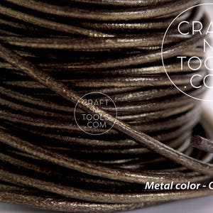 May include: Close-up of a spool of brown leather cord with a metallic gold finish. The cord is wound tightly and has a smooth, textured surface. The text "CRAFT N TOOLS .COM" is visible on the spool.