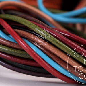 May include: A close-up of a bundle of colorful leather cords. The cords are in various shades of brown, red, green, and blue. The cords are arranged in a circular pattern, with the ends of the cords overlapping. The cords are all of the same thickness and are smooth to the touch. The cords are perfect for crafting projects, such as jewelry making, leatherworking, and macrame.