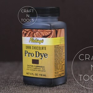 May include: A 4-ounce bottle of Fiebing's Pro Dye in Dark Chocolate. The bottle is labeled with the product name, color, and safety information. It is a leather dye for crafting projects.