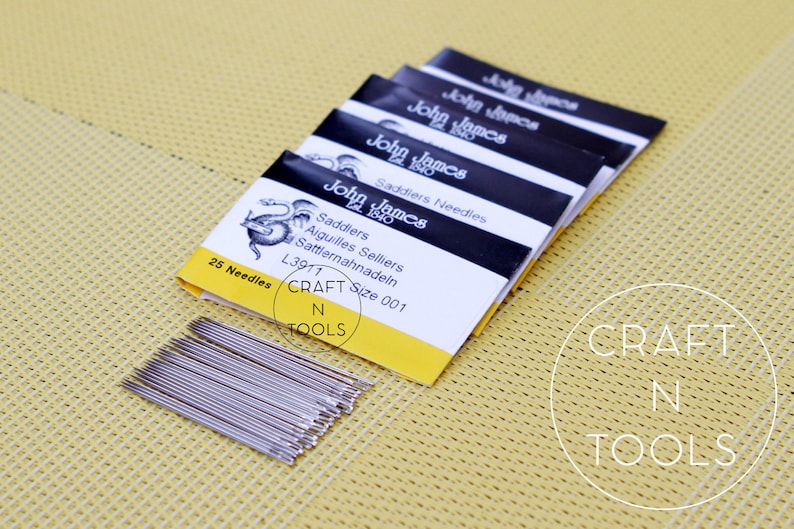 May include: A pack of 25 John James Saddlers needles, size 001, in a yellow and black package with a dragon illustration. The package says "Saddlers Aiguilles Selliers Sattlernahnadeln L3911 Size 001".