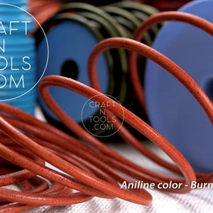 May include: Close-up of a spool of burnt orange leather cord. The cord is coiled and has a smooth, polished finish. The text "CRAFT N TOOLS .COM" is visible on the spool.