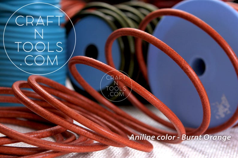 May include: Close-up of a spool of burnt orange leather cord. The cord is coiled and has a smooth, polished finish. The text "CRAFT N TOOLS .COM" is visible on the spool.
