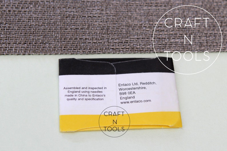 May include: A yellow and black packaging label with the text "CRAFT N TOOLS" and information about the product's assembly and manufacturer, Entaco Ltd. The label reads "Assembled and inspected in England using needles made in China to Entaco's quality and specification" and "Entaco Ltd. Redditch, Worcestershire, B98 OEA England www.entaco.com".