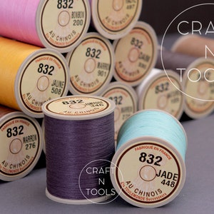 May include: A close-up of a variety of spools of thread in different colors, including pink, yellow, brown, purple, and blue. The spools are labeled with the brand name "Au Chinois" and the color name and number. The spools are arranged in a pyramid shape. The text "CRAFT N TOOLS" is visible in the background.