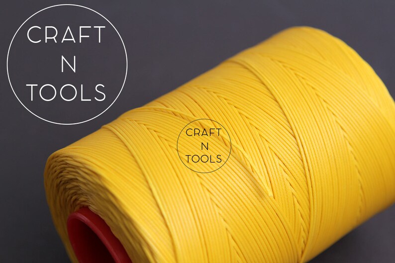 Puede incluir: Una bobina de hilo encerado amarillo brillante. El hilo est&aacute; enrollado apretado y tiene una textura lisa y uniforme. La bobina est&aacute; etiquetada con "CRAFT N TOOLS".