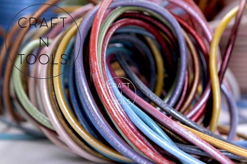 May include: A close-up of a bundle of colorful leather cords. The cords are arranged in a circular pattern, with the ends of the cords overlapping. The cords are a variety of colors, including red, blue, green, yellow, and purple. The cords are all smooth and shiny, and they appear to be made of high-quality leather. The text "CRAFT N TOOLS" is visible in the background.
