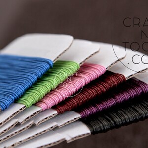 May include: A set of six spools of waxed cotton cord in various colors, including blue, green, pink, burgundy, purple, and black. The spools are stacked on top of each other and labeled "CRAFT N TOOLS .COM".