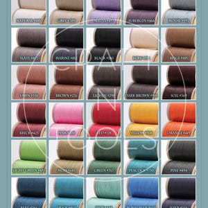 May include: A color chart of 25 spools of linen thread, each wound on a wooden spool. The spools are arranged in a grid of five rows and five columns. Each spool is labeled with a color name and a number. The colors include natural, grey, mauve, aubergine, mouse, slate, marine, black, ecru, beige, fawn, brown, lichen, dark brown, soil, brick, pink, red, yellow, orange, light green, moss, green, peacock, pine, bleu, duck, jade, royal blue, navy, and violet.