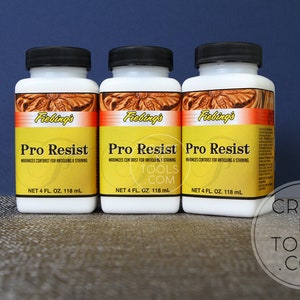May include: Three bottles of Fiebing's Pro Resist leather conditioner. Each bottle is white with a yellow label and contains 118 ml.