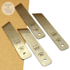 Op de afbeelding: Vier metalen leersnijgereedschappen met schuine bladen en afgeronde uiteinden worden getoond. Elk gereedschap heeft de tekst "REF 3.10110" of "REF 3.10120", "The Cutting Edge Leather Tools Since 1823" en "BLANCHARD - FRANCE". Het Craft N Tools .com logo is ook zichtbaar.