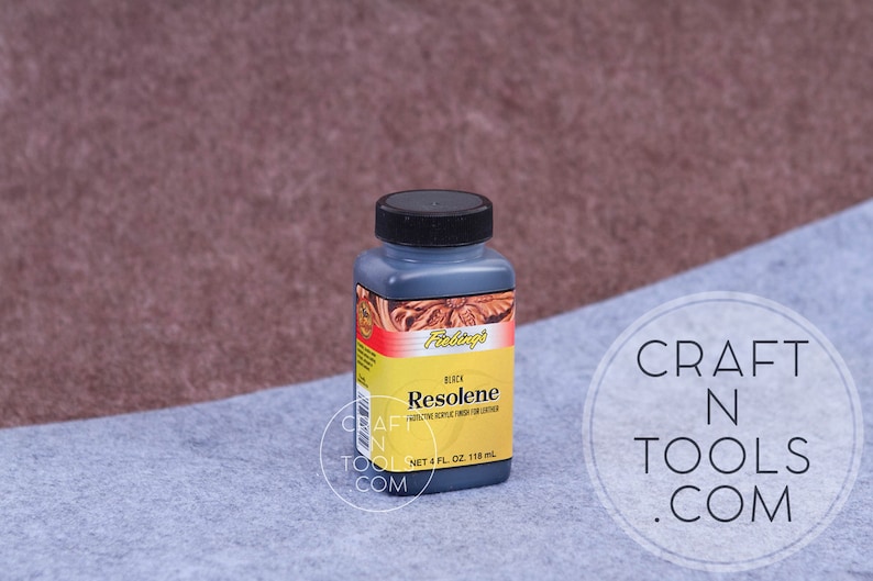 K&ouml;nnte beinhalten: Eine 118 ml Flasche schwarzer Fiebing's Resolene Lederfinish. Die Flasche hat ein schwarzes Etikett mit wei&szlig;em Text, auf dem "BLACK Resolene PROTECTIVE EPOXY FINISH FOR LEATHER NET 4 FL OZ 118 ml" steht.