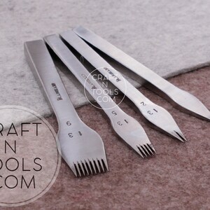 May include: Four silver leather stitching tools with different sized prongs. The tools are labeled with numbers 1, 2, 3, and 6. The tools are on a gray and brown surface. "CRAFT N TOOLS .COM" is printed on the surface.