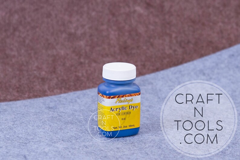 May include: A blue bottle of Fiebing's Acrylic Dye for Leather in the color blue. The bottle is labeled with the brand name, product name, and color. The bottle is 2 oz (59 ml).