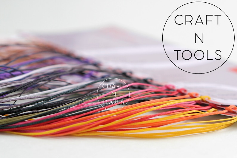May include: A close-up of a variety of colorful cords, including yellow, orange, red, pink, black, and gray. The cords are arranged in a fan shape and are tied together at the top. The text "CRAFT N TOOLS" is visible in the background.