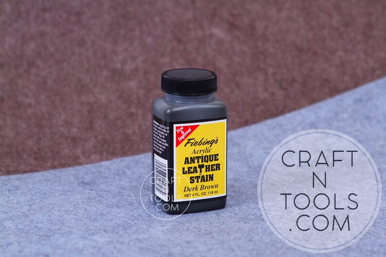 May include: A 4-ounce bottle of Fiebing's Antique Leather Stain in Dark Brown. The bottle is black with a yellow label and the text "Fiebing's Acrylic Antique Leather Stain Dark Brown NET 4 FL OZ. 118 ml" is printed on the label.
