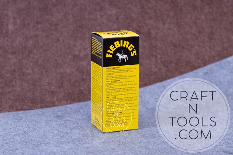May include: A yellow and black box of Fiebing's Leather Dye. The box has a picture of a person riding a horse. The text on the box reads "Fiebing's" and "Leather Dye".