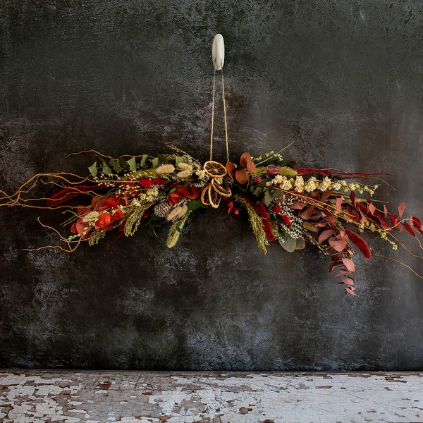 Christmas Dried Flower Display.  A handmade festive garland made onto a natural branch with dried flowers. Hang or place above mantlepiece